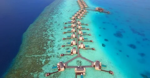 Aerial drone view of a scenic tropical island and resort hotel with overwater bu Stock Footage