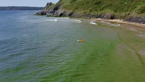 Aerial drone view of sea coast with a couple kyaking to the beach. Stock Footage 194508341