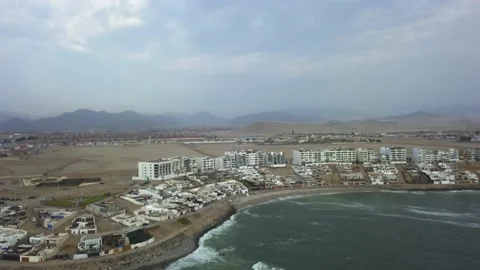Aerial drone view of several beach houses with background of hills and desert in Video stock 195968406