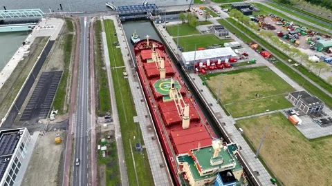 Aerial drone view of a ship passing through a canal sea lock in the Netherlands Stock Footage 302447091
