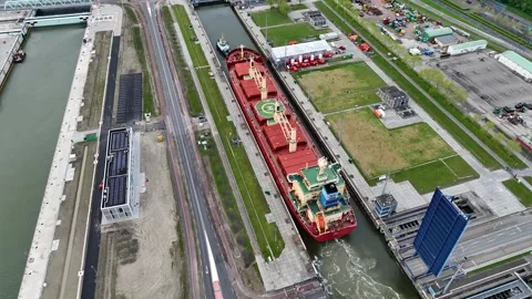 Aerial drone view of a ship passing through a canal sea lock in the Netherlands Stock Footage 309128832