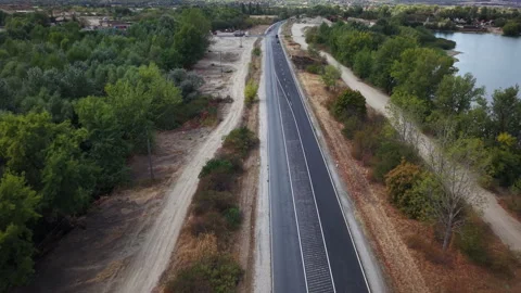An aerial drone view shows a white van traveling along a straight highway Stock Footage 345620295