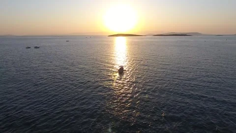 Aerial drone view of a single boat at sunset on the sea - Evening Light Stock Footage 339802283