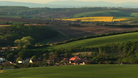 Aerial drone view of a small Czech village in a valley surrounded by layered Stock Footage 336615461