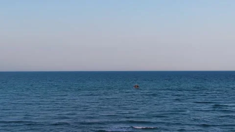 Aerial drone view of a small lonely boat on vast deep blue ocean at dusk Stock Footage 346168401