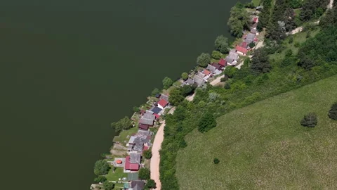 An aerial drone view of a small riverside village in Hungary, showing cozy Видео 336704511