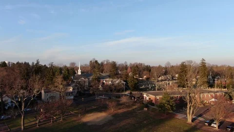 Aerial drone view of small town church over a park setting during sunset Stock Footage 100385980