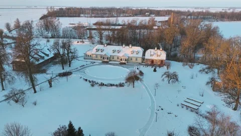 Aerial drone view of snow covered rural estate with houses and frozen pond near 스톡 동영상 333645571