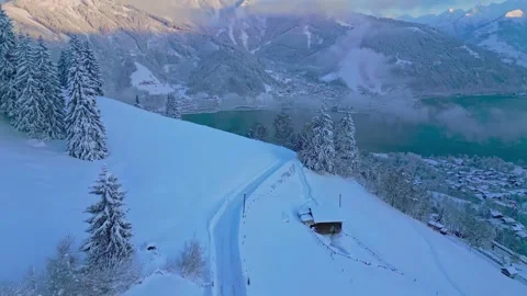 Aerial drone view of snowy alpine mountain and lake at sunrise Stock Footage 345467091