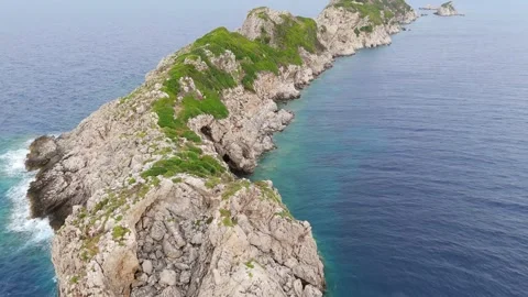 Aerial Drone View of Solid Rocky Spit Leaning Over Deep Blue Sea Stock Footage 315073667