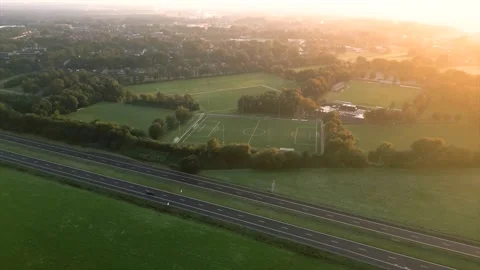 Aerial drone view of sports fields and highway at sunrise Stock Footage 346323625