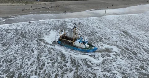 Aerial drone view of a stranded small shrimp trawler fishing boat at a beach. Stockbeeldmateriaal 258374122