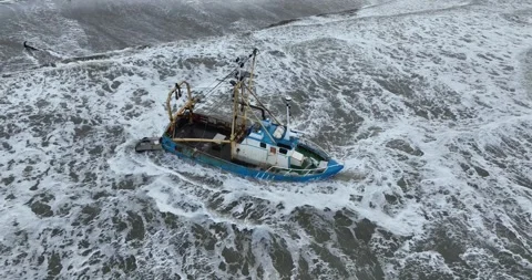 Aerial drone view of a stranded small shrimp trawler fishing boat at a beach. 스톡 동영상 258596829