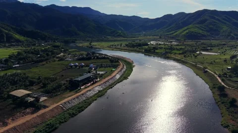 Aerial drone view of sun reflection on river in lush mountain valley 스톡 동영상 336610234