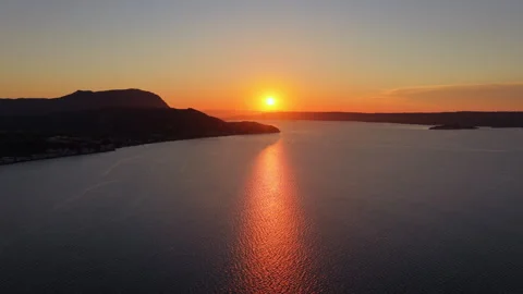 Aerial drone view of the sun setting into the narrow mouth of a large enclosed Видео 339304350
