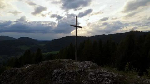 Aerial drone view of sunset over cross on mountain hilltop with dramatic sky i 動画素材 317648339
