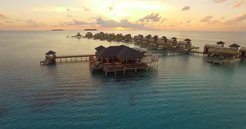 Aerial drone view at sunset of a scenic tropical island and resort hotel with ov Stock Footage