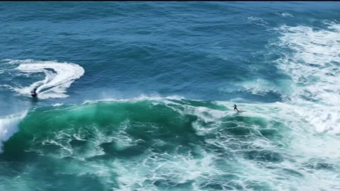 Aerial drone view of a surfer riding massive waves at Nazare, Portugal Stock Footage 287731484