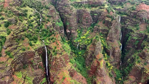 Aerial drone view of a thin waterfall falling down the red rock wall of the Stock Footage 344991491