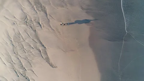 Aerial drone view of three men walking by the beach to the water with surf .. Stock-Footage 269423809
