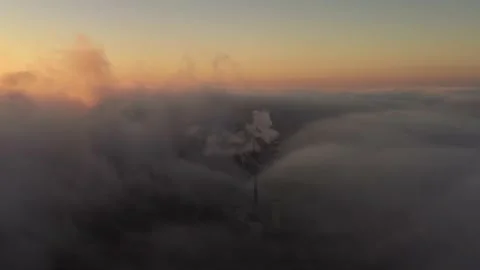 Aerial drone view through the clouds on the industrial pipes in a sunset Video stock 143558270