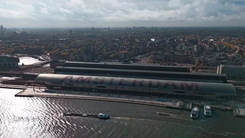 Aerial drone view time laps Amsterdam Central Train Station with Amsterdam sign  Vidéo 254863982