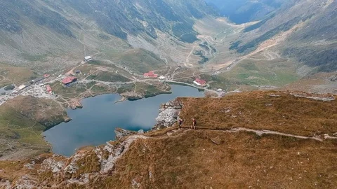 Aerial drone view tracking shot of young couple hiking on a mountain top Stock Footage 96530863