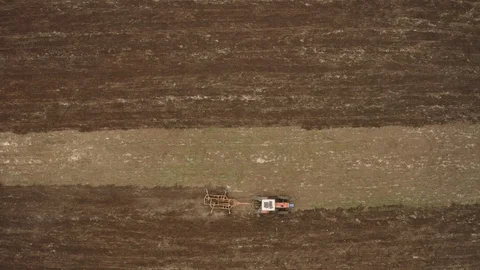 Aerial drone view of tractor plowing in the field and preparing land for sowing. Stock Footage 129769832