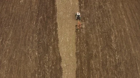 Aerial drone view of tractor plowing in the field and preparing land for sowing. Stock Footage 129770555