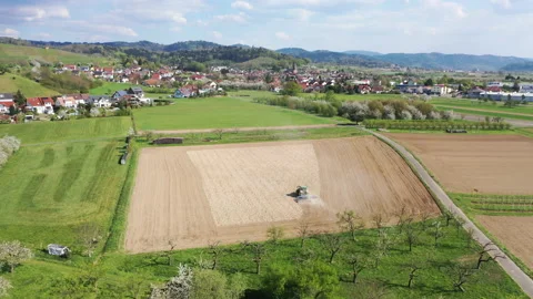 Aerial drone view. Tractor plows a field near Ortenberg in the Black Forest Stock Footage 137950857