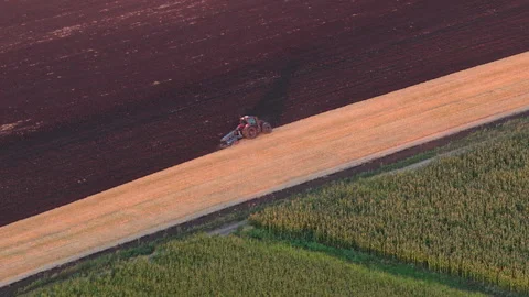 Aerial drone view of Tractor working a field, preparing soil for new crops with Stock Footage 345501203