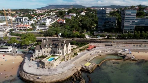 Aerial drone view of train approaching Cascais train station close to the sea Stock Footage 247979471