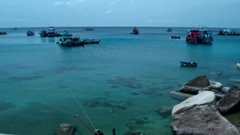 Aerial drone view of a tranquil harbor with colorful boats, including a green Stock Footage 309234531