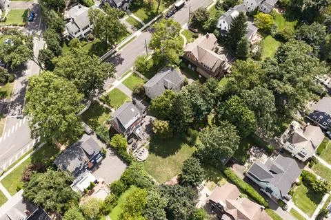 Aerial drone view of tree-lined residential neighborhood with detached homes and Stockfoto's
