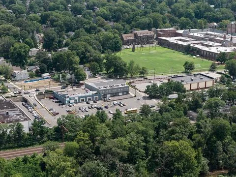 Aerial drone view of tree-lined residential neighborhood with detached homes and Stock Photos