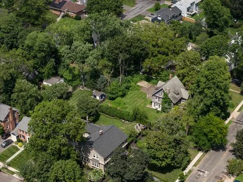 Aerial drone view of tree-lined residential neighborhood with detached homes Фото