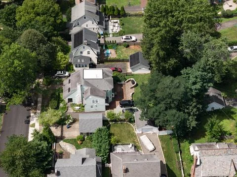 Aerial drone view of tree-lined residential neighborhood with detached homes 스톡 사진