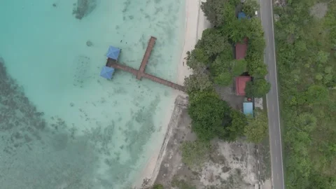 Aerial drone view of tropical beach, turquoise ocean water, and coastal road. Stock Footage 345426061