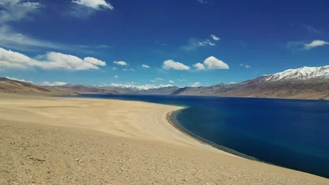Aerial drone view of Tso Moriri’s deep blue waters surrounded by snow-kissed Stock Footage 310806909