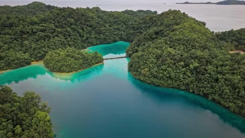 Aerial drone view of turquoise blue lagoon with tropical jungle and mountain Stock Footage 345750353