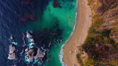 Aerial drone view of turquoise ocean waves hitting sandy beach coastline Stock Footage 343696394
