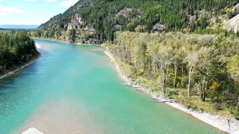 Aerial drone view of turquoise river flowing around white sandbar with forested 스톡 동영상 330801817