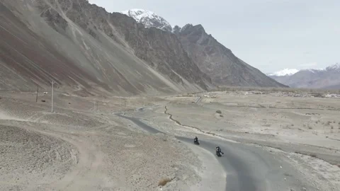 Aerial drone view of two bikers riding their bikes in a straight road in the  Stock Footage 154232448