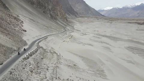 Aerial drone view of two bikers riding through the road of Nubra Valley in La Vídeo Stock 154232470