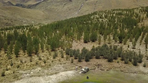 Aerial drone view of two friends at Radian lagoon in the Peruvian highlands of Stock Footage 164599299