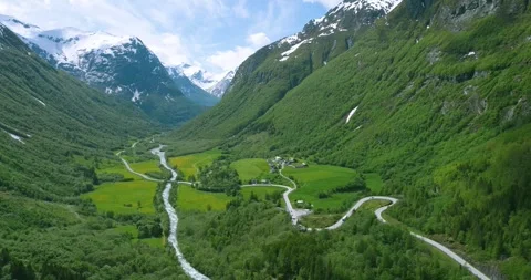 Aerial Drone View of Valley with River and Snow Capped Mountains (Norway) Stock Footage 247378257