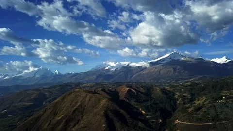 Aerial drone view of various snow-capped mountains over mountains with dramatic Stock Footage 164590934
