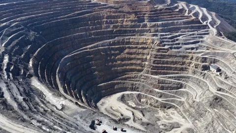 Aerial drone view of a vast open-pit mine with dramatic terraced levels Stock Footage 345163030
