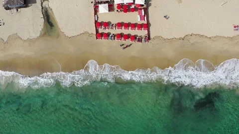 Aerial Drone View of Vibrant Blue Beach with Red Umbrellas Stock Footage 339090781