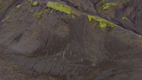 Aerial drone view of volcanic terrain with moss-covered lava fields and glacial Stock Footage 341606304